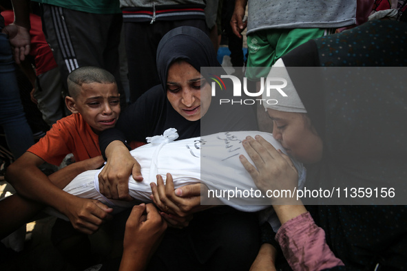 Mourners are reacting next to the bodies of Palestinians killed in Israeli strikes, amid the Israel-Hamas conflict, at Al-Aqsa hospital in D...