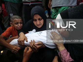 Mourners are reacting next to the bodies of Palestinians killed in Israeli strikes, amid the Israel-Hamas conflict, at Al-Aqsa hospital in D...