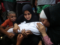 Mourners are reacting next to the bodies of Palestinians killed in Israeli strikes, amid the Israel-Hamas conflict, at Al-Aqsa hospital in D...