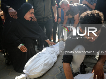 Mourners are reacting next to the bodies of Palestinians killed in Israeli strikes, amid the Israel-Hamas conflict, at Al-Aqsa hospital in D...