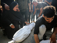 Mourners are reacting next to the bodies of Palestinians killed in Israeli strikes, amid the Israel-Hamas conflict, at Al-Aqsa hospital in D...