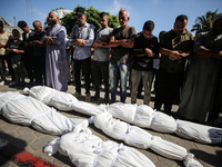 Palestinian mourners are performing a prayer during the funeral of Palestinians killed in Israeli strikes, amid the Israel-Hamas conflict, a...