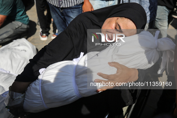 A mourner is reacting next to the bodies of Palestinians killed in Israeli strikes, amid the Israel-Hamas conflict, at Al-Aqsa hospital in D...