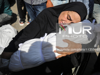 A mourner is reacting next to the bodies of Palestinians killed in Israeli strikes, amid the Israel-Hamas conflict, at Al-Aqsa hospital in D...