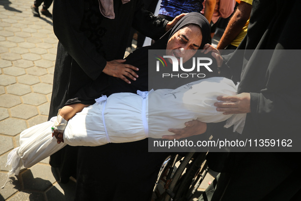 A mourner is reacting next to the bodies of Palestinians killed in Israeli strikes, amid the Israel-Hamas conflict, at Al-Aqsa hospital in D...