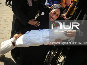 A mourner is reacting next to the bodies of Palestinians killed in Israeli strikes, amid the Israel-Hamas conflict, at Al-Aqsa hospital in D...