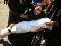 A mourner is reacting next to the bodies of Palestinians killed in Israeli strikes, amid the Israel-Hamas conflict, at Al-Aqsa hospital in D...