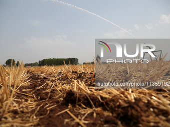 Farmers are watering corn seedlings by sprinkling machine in Shiegangbu village, Zaozhuang city, East China's Shandong province, in Zaozhuan...