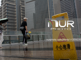 People are walking with umbrellas in Shanghai, China, on June 25, 2024, as China is issuing a rainstorm alert due to a deadly thunderstorm m...