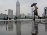 A man is walking with an umbrella at Bingjiang Dadao along the Huangpu River in Shanghai, China, on June 25, 2024, as China is issuing a rai...