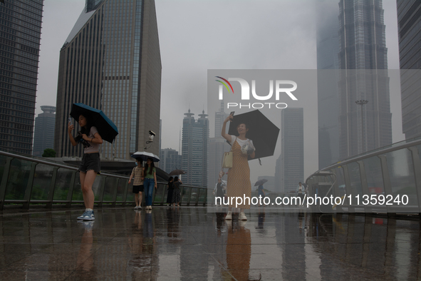 People are taking pictures at Lujiazui in Pudong in Shanghai, China, on June 25, 2024, as China is issuing a rainstorm alert due to a deadly...