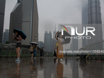 People are taking pictures at Lujiazui in Pudong in Shanghai, China, on June 25, 2024, as China is issuing a rainstorm alert due to a deadly...