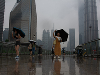 People are taking pictures at Lujiazui in Pudong in Shanghai, China, on June 25, 2024, as China is issuing a rainstorm alert due to a deadly...