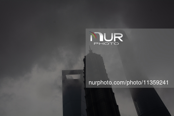 Skyscrapers are being seen under the heavy dark clouds at Lujiazui in Pudong in Shanghai, China, on June 25, 2024, as China is issuing a rai...