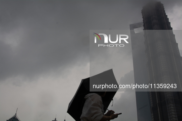 Skyscrapers are being seen under the heavy dark clouds at Lujiazui in Pudong in Shanghai, China, on June 25, 2024, as China is issuing a rai...