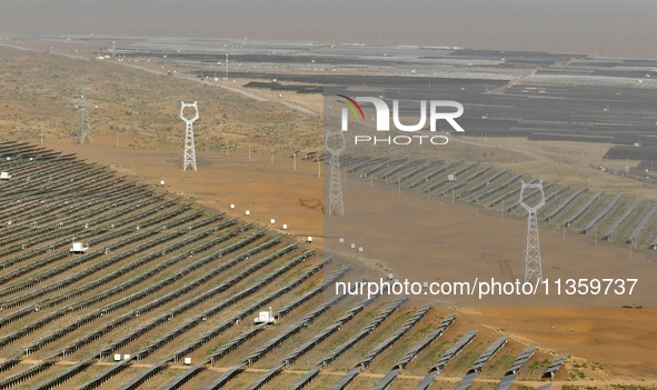 A new energy base is forming a blue ''photovoltaic ocean'' that is continuously producing green electricity in Zhongwei, China, on June 25,...