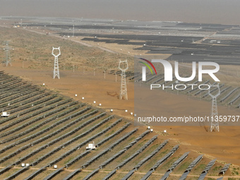 A new energy base is forming a blue ''photovoltaic ocean'' that is continuously producing green electricity in Zhongwei, China, on June 25,...