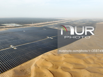 A new energy base is forming a blue ''photovoltaic ocean'' that is continuously producing green electricity in Zhongwei, China, on June 25,...