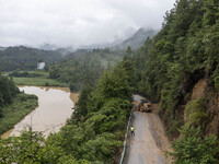 Aerial photo crews are driving machinery to clear a damaged road caused by a landslide in Yongli village, Congjiang county, Southwest China'...