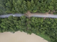 Aerial photo crews are driving machinery to clear a damaged road caused by a landslide in Yongli village, Congjiang county, Southwest China'...