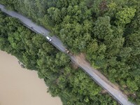 Aerial photo crews are driving machinery to clear a damaged road caused by a landslide in Yongli village, Congjiang county, Southwest China'...