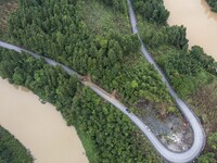 Aerial photo crews are driving machinery to clear a damaged road caused by a landslide in Yongli village, Congjiang county, Southwest China'...