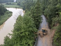 Aerial photo crews are driving machinery to clear a damaged road caused by a landslide in Yongli village, Congjiang county, Southwest China'...