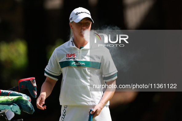 Charley Hull of England smokes as she waits on the second green during Day Four of the KPMG Women's PGA Championship at Sahalee Country Club...