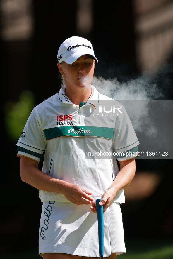 Charley Hull of England smokes as she waits on the second green during Day Four of the KPMG Women's PGA Championship at Sahalee Country Club...