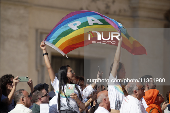 People are holding Peace flags during Pope Francis' weekly general audience in St. Peter's Square in The Vatican, on June 26, 2024. 