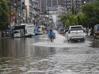 A delivery man is riding a bicycle through a waterlogged street during heavy rainfall in Dhaka, Bangladesh, on June 26, 2024. (