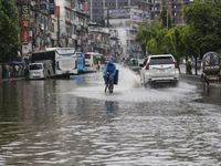 A delivery man is riding a bicycle through a waterlogged street during heavy rainfall in Dhaka, Bangladesh, on June 26, 2024. (