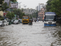 People are making their way through a waterlogged street during heavy rainfall in Dhaka, Bangladesh, on June 26, 2024. (