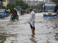 A man is walking through a waterlogged street during heavy rainfall in Dhaka, Bangladesh, on June 26, 2024. (