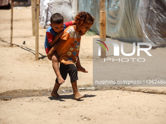 Displaced Palestinian children are playing outside their tent in Deir el-Balah, on June 26, 2024, amid the ongoing conflict between Israel a...