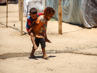 Displaced Palestinian children are playing outside their tent in Deir el-Balah, on June 26, 2024, amid the ongoing conflict between Israel a...