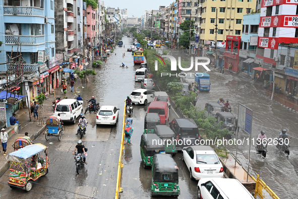 Vehicles and rickshaws are trying to drive with passengers through the waterlogged streets caused by heavy monsoon rainfalls in Dhaka, Bangl...