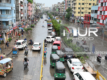 Vehicles and rickshaws are trying to drive with passengers through the waterlogged streets caused by heavy monsoon rainfalls in Dhaka, Bangl...