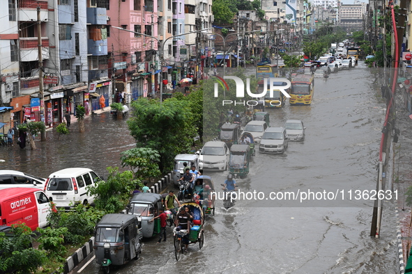 Vehicles and rickshaws are trying to drive with passengers through the waterlogged streets caused by heavy monsoon rainfalls in Dhaka, Bangl...