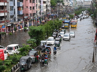 Vehicles and rickshaws are trying to drive with passengers through the waterlogged streets caused by heavy monsoon rainfalls in Dhaka, Bangl...