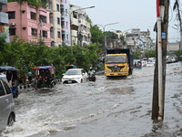 Vehicles and rickshaws are trying to drive with passengers through the waterlogged streets caused by heavy monsoon rainfalls in Dhaka, Bangl...