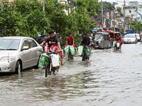 Vehicles and rickshaws are trying to drive with passengers through the waterlogged streets caused by heavy monsoon rainfalls in Dhaka, Bangl...