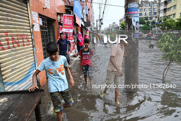 Vehicles and rickshaws are trying to drive with passengers through the waterlogged streets caused by heavy monsoon rainfalls in Dhaka, Bangl...