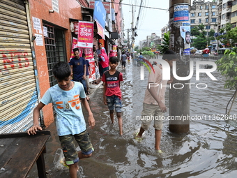 Vehicles and rickshaws are trying to drive with passengers through the waterlogged streets caused by heavy monsoon rainfalls in Dhaka, Bangl...