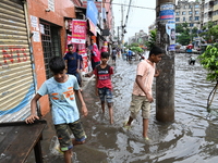 Vehicles and rickshaws are trying to drive with passengers through the waterlogged streets caused by heavy monsoon rainfalls in Dhaka, Bangl...