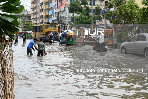 Vehicles and rickshaws are trying to drive with passengers through the waterlogged streets caused by heavy monsoon rainfalls in Dhaka, Bangl...