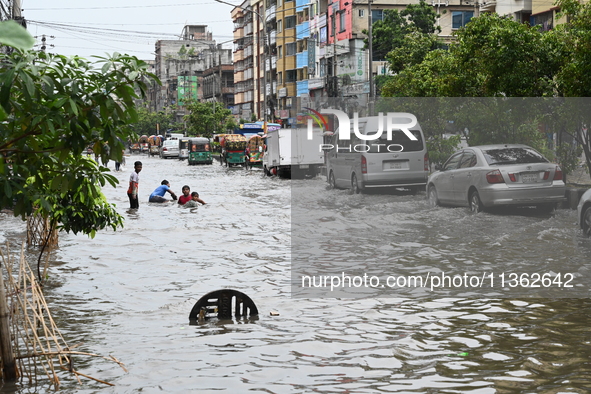 Vehicles and rickshaws are trying to drive with passengers through the waterlogged streets caused by heavy monsoon rainfalls in Dhaka, Bangl...