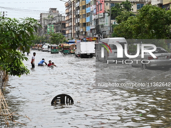 Vehicles and rickshaws are trying to drive with passengers through the waterlogged streets caused by heavy monsoon rainfalls in Dhaka, Bangl...