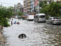 Vehicles and rickshaws are trying to drive with passengers through the waterlogged streets caused by heavy monsoon rainfalls in Dhaka, Bangl...