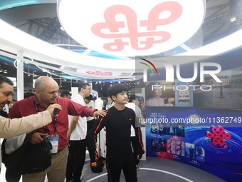 Foreign visitors are learning about China Unicom's digital people technology at the 2024 Mobile World Congress (MWC Shanghai) in Shanghai, C...